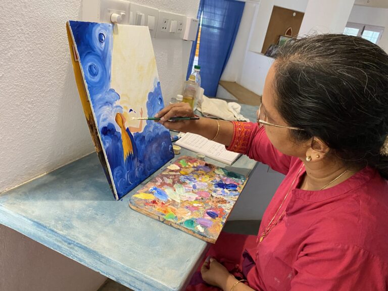 A Savitri Art painter at work on a canvas